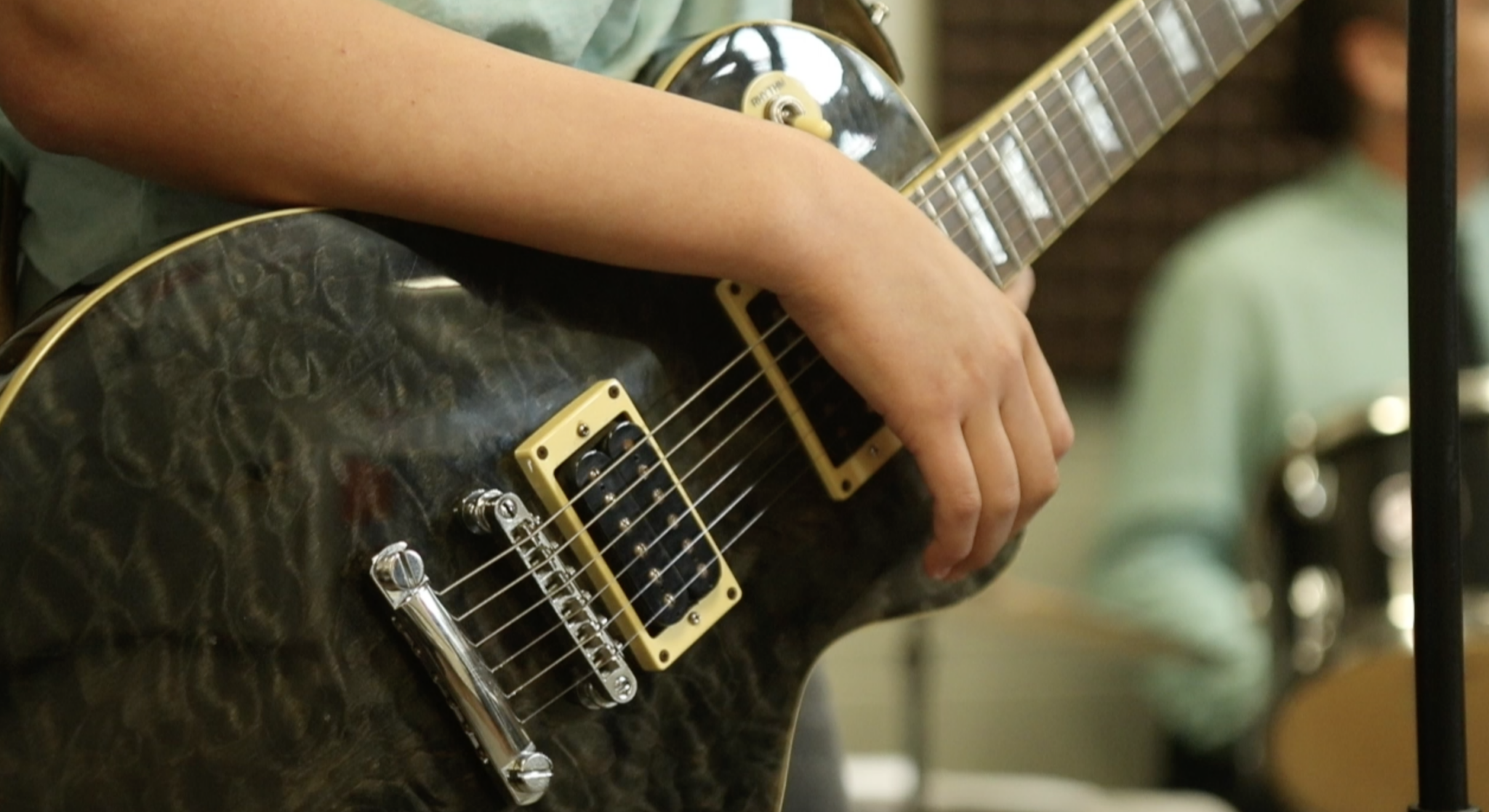 Teen plays electric guitar at alternative school for learning differently